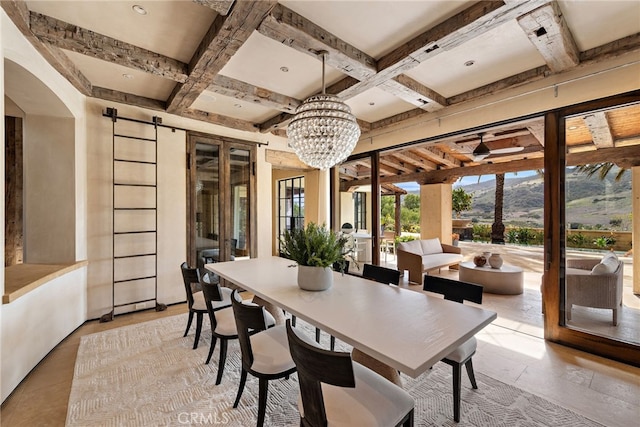 dining area featuring a mountain view, a barn door, coffered ceiling, and beam ceiling