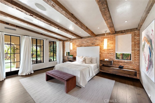 bedroom with brick wall, access to outside, wood-type flooring, and beamed ceiling