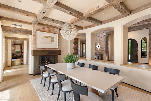 dining area with a lit fireplace, visible vents, coffered ceiling, and beamed ceiling