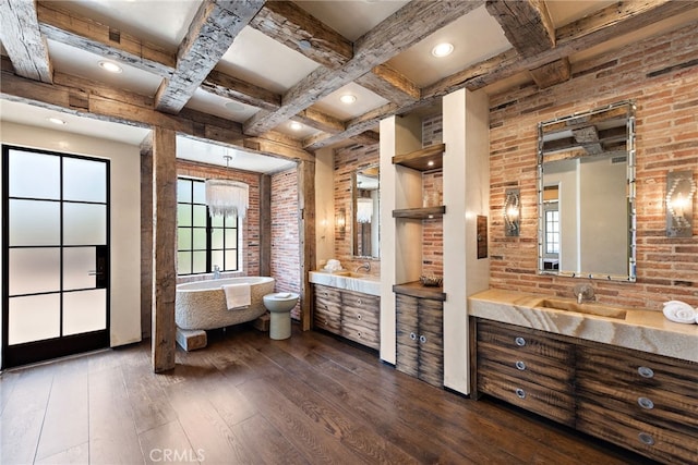 full bathroom with coffered ceiling, a sink, brick wall, and hardwood / wood-style flooring