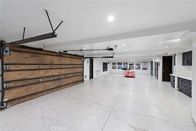 garage with recessed lighting and a garage door opener