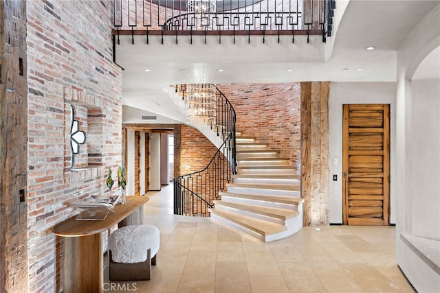 31 Blue Heron, Irvine, CA 92603 - foyer featuring stairway, recessed lighting, a towering ceiling, arched walkways, and brick wall