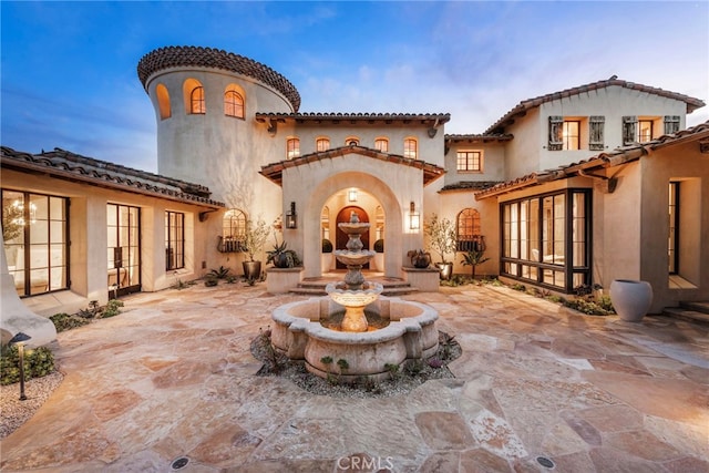 back of property with stucco siding and french doors