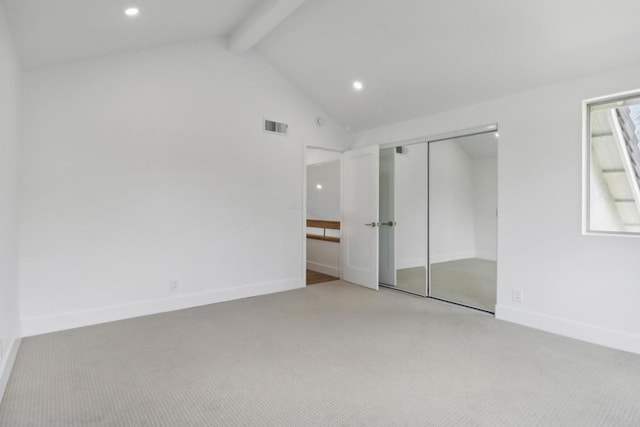 unfurnished bedroom with lofted ceiling with beams, light colored carpet, visible vents, baseboards, and a closet