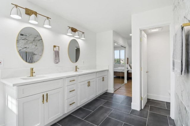 full bathroom featuring tile patterned flooring, a sink, ensuite bath, and double vanity