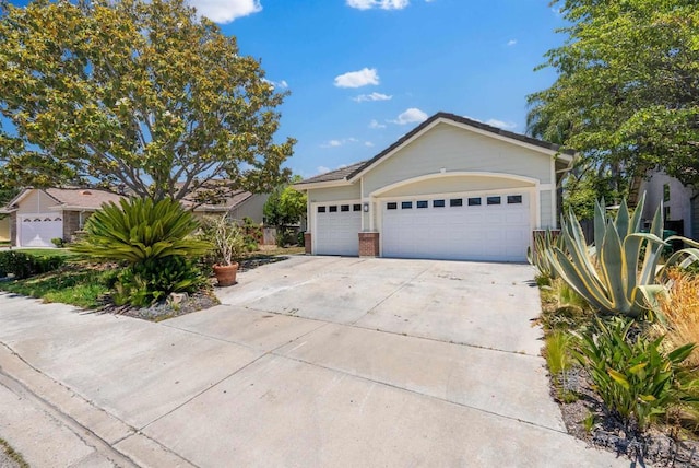 ranch-style house with a garage, brick siding, and driveway