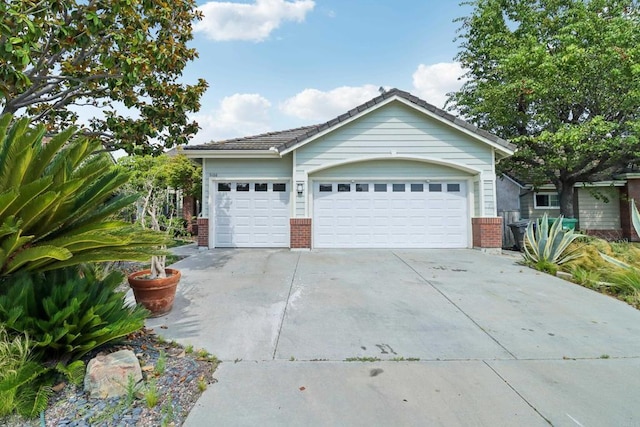 exterior space featuring a garage and brick siding