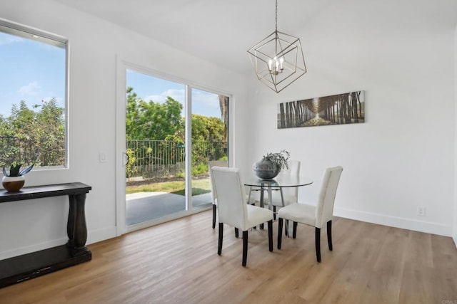 dining area featuring light wood-style floors, baseboards, and a chandelier