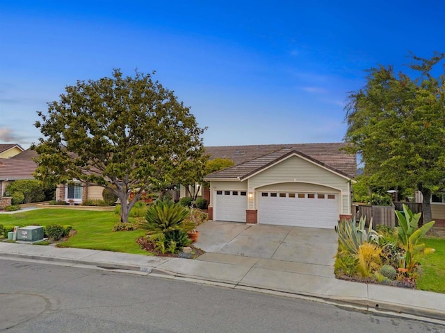 view of front of home featuring concrete driveway, a tile roof, an attached garage, a front lawn, and brick siding