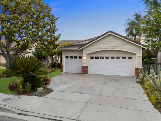 single story home with driveway and brick siding