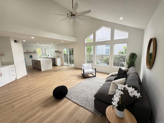 living area featuring light wood-style floors, recessed lighting, visible vents, and baseboards