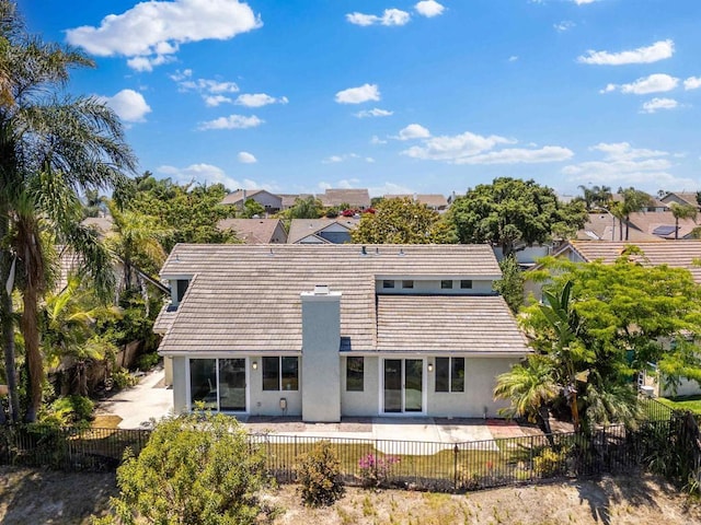 rear view of house featuring a fenced backyard, a residential view, a patio, and stucco siding