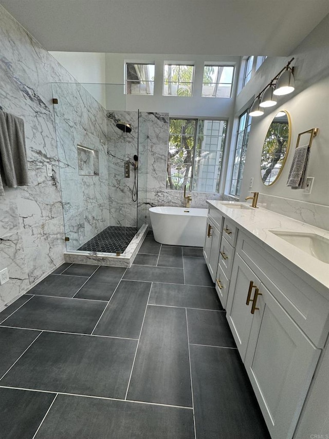 bathroom with a marble finish shower, a sink, a freestanding bath, and double vanity