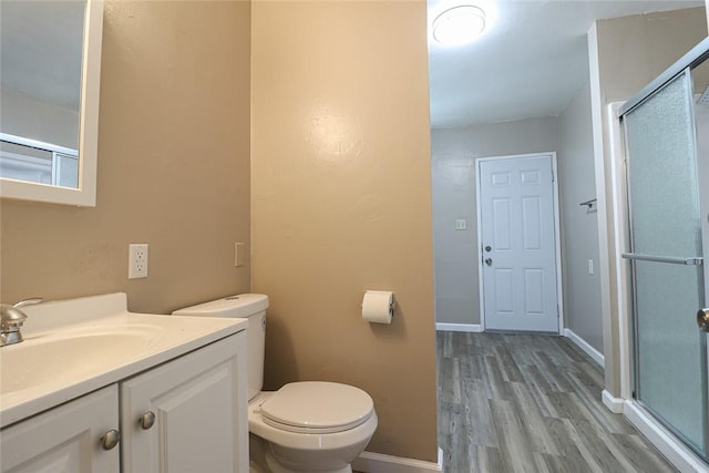 full bath with toilet, an enclosed shower, vanity, wood finished floors, and baseboards