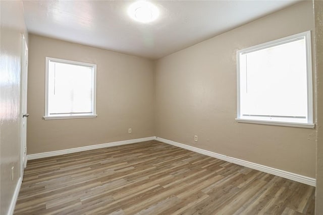 empty room with baseboards and wood finished floors