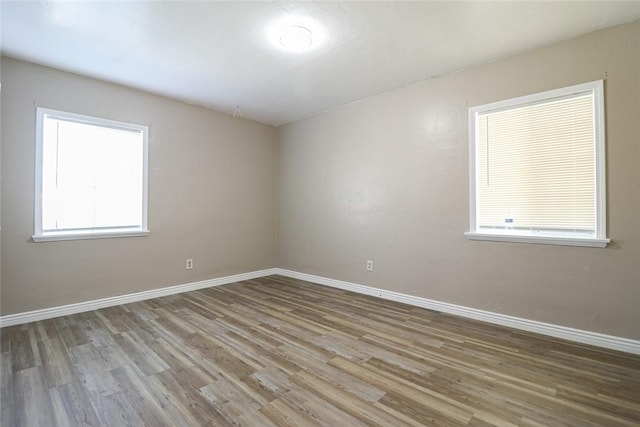 spare room featuring light wood finished floors and baseboards