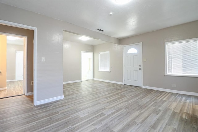 entrance foyer featuring light wood-style flooring, visible vents, and baseboards