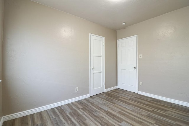 unfurnished room with baseboards and wood finished floors