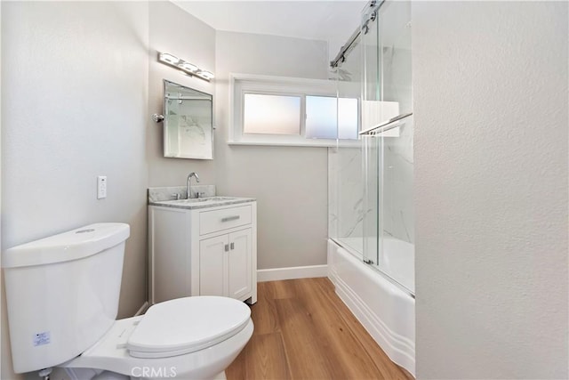 full bathroom with enclosed tub / shower combo, toilet, wood finished floors, vanity, and baseboards