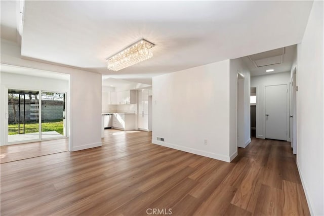 unfurnished living room with light wood-type flooring, visible vents, and baseboards