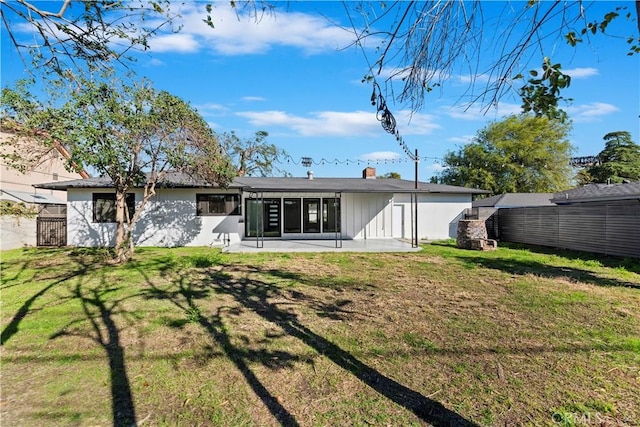 back of property featuring a patio area and a lawn