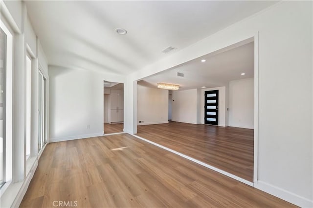 spare room with baseboards, light wood finished floors, visible vents, and recessed lighting