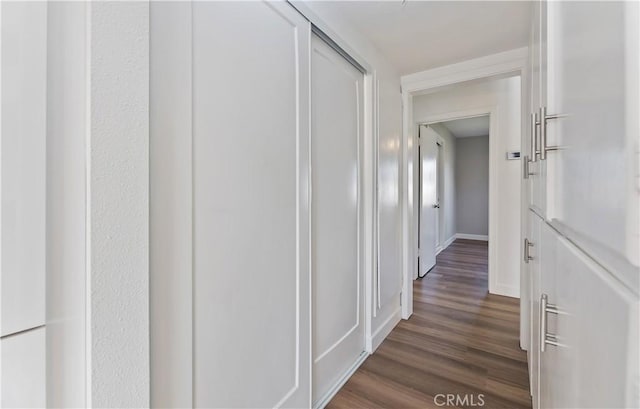 hallway with dark wood-style floors and baseboards