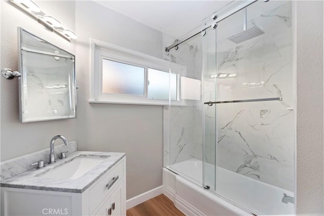 full bathroom with shower / bath combination with glass door, vanity, baseboards, and wood finished floors