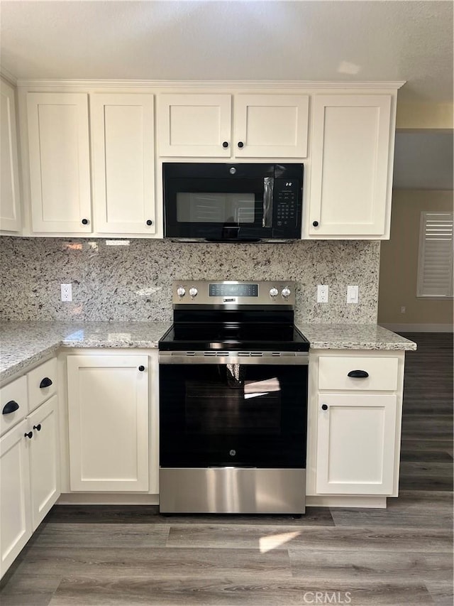 kitchen featuring black microwave, decorative backsplash, stainless steel electric range oven, light wood-type flooring, and white cabinetry