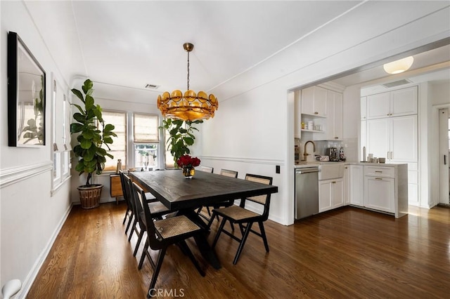 dining area with dark wood-type flooring, visible vents, and a notable chandelier