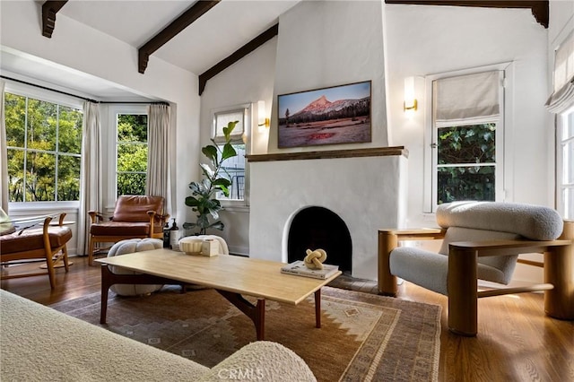 sitting room with lofted ceiling with beams, a fireplace, and dark wood finished floors