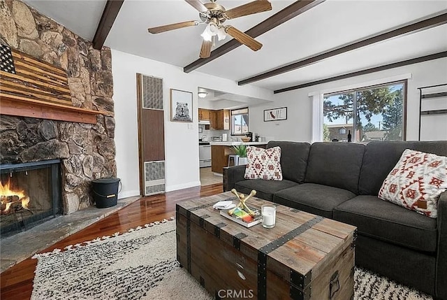 living area with baseboards, beam ceiling, a wealth of natural light, and light wood-style floors