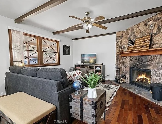 living area with baseboards, a ceiling fan, dark wood-style floors, a fireplace, and beam ceiling