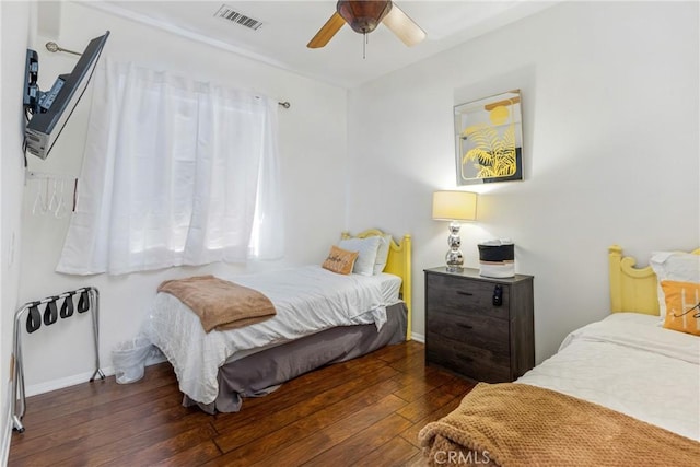 bedroom with dark wood-type flooring, visible vents, ceiling fan, and baseboards