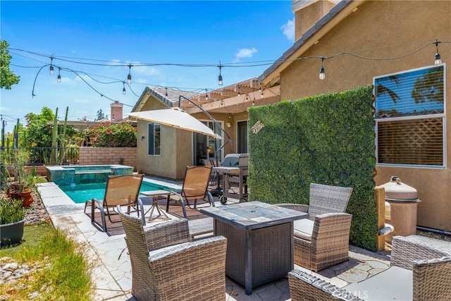 view of patio / terrace with a pool with connected hot tub, an outdoor fire pit, and fence