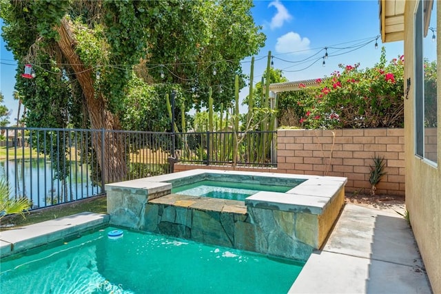 view of pool with a fenced backyard, a water view, and an in ground hot tub