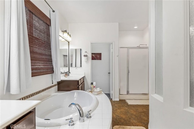 bathroom with a garden tub, a shower stall, and vanity