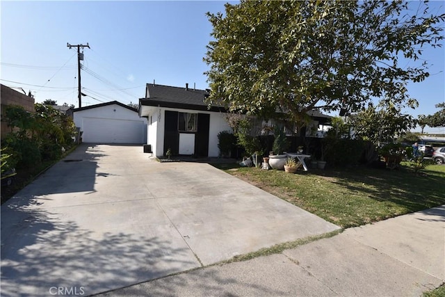 ranch-style home with a garage, stucco siding, an outdoor structure, and a front yard