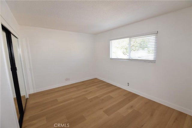 unfurnished room featuring light wood-type flooring and baseboards