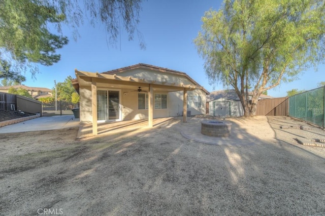 rear view of house featuring an outdoor fire pit, a patio area, a fenced backyard, and stucco siding