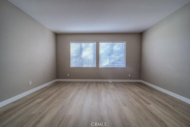 spare room with light wood-style flooring and baseboards