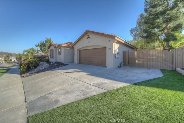 view of front of property with a tiled roof, driveway, a gate, and stucco siding