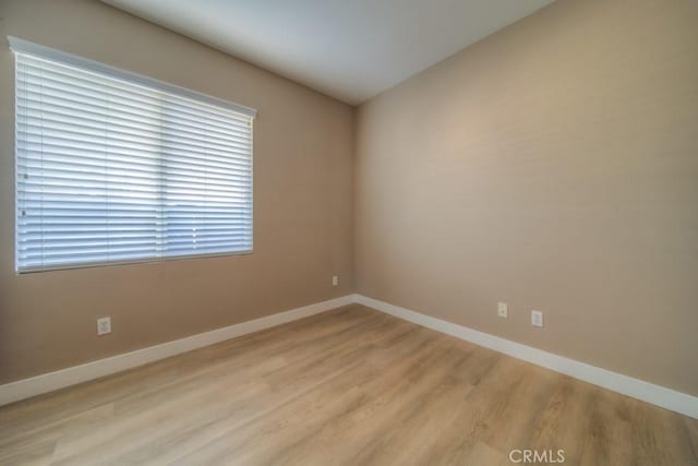 unfurnished room featuring light wood finished floors and baseboards