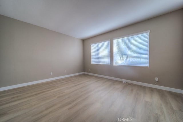 empty room with light wood finished floors and baseboards