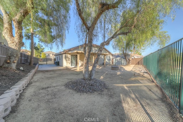 exterior space featuring stucco siding, a fenced backyard, an outdoor structure, and a shed