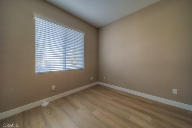 empty room with light wood-style flooring and baseboards