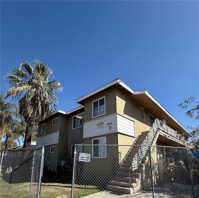 view of front of house featuring fence and stucco siding