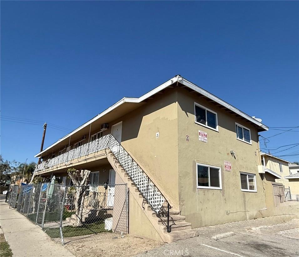 view of building exterior featuring stairway and fence