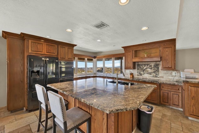 29345 Wilkes Rd, Valley Center, CA 92082 - kitchen with black appliances, stone tile floors, recessed lighting, brown cabinetry, and decorative backsplash