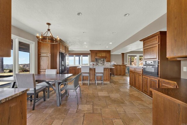29345 Wilkes Rd, Valley Center, CA 92082 - dining room featuring healthy amount of natural light, stone tile floors, a chandelier, and recessed lighting